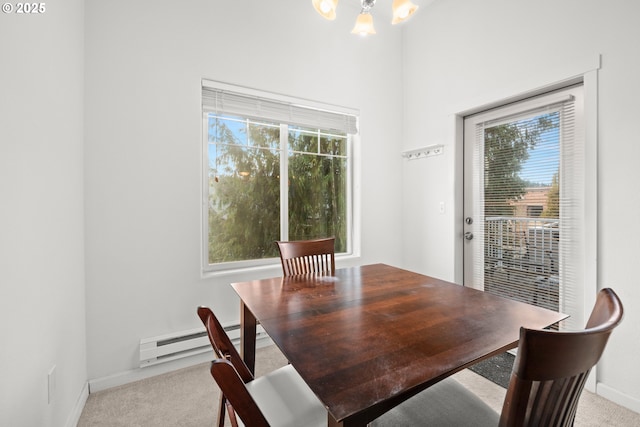 dining area featuring light carpet, a chandelier, and a baseboard heating unit