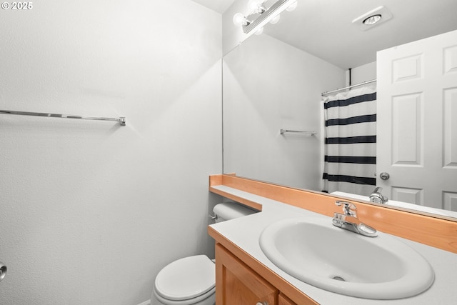 bathroom featuring vanity, curtained shower, and toilet