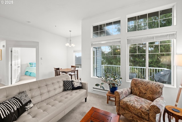 living room featuring a baseboard heating unit, carpet floors, and a notable chandelier