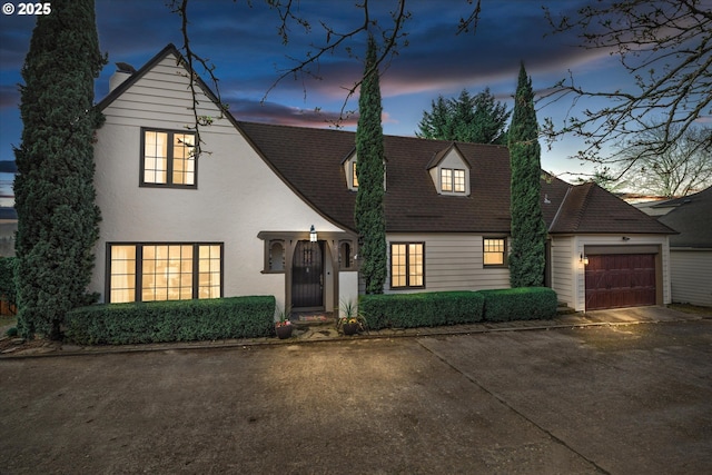 view of front of house with concrete driveway, an attached garage, and stucco siding