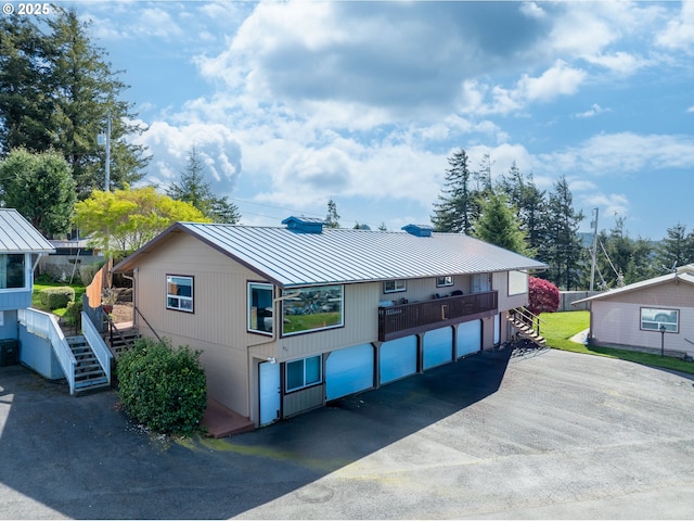 625 Crestview Dr, Reedsport, OR 97467 - view of front of home with stairway, a standing seam roof, metal roof, and asphalt driveway