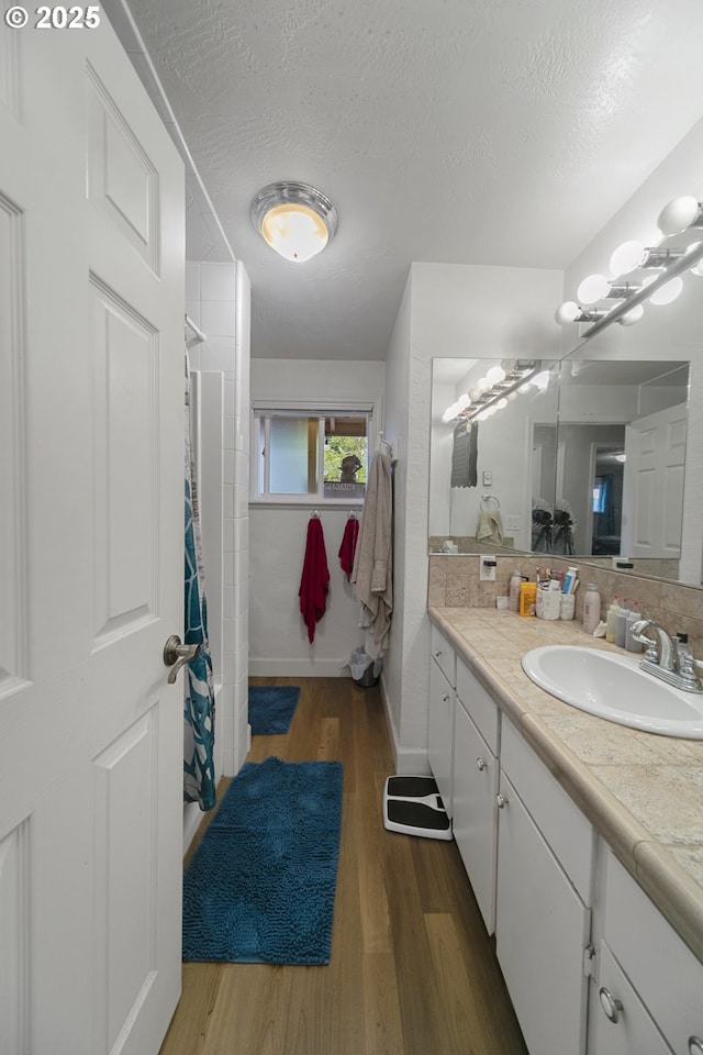 625 Crestview Dr, Reedsport, OR 97467 - bathroom featuring vanity, a shower with curtain, wood finished floors, a textured ceiling, and baseboards