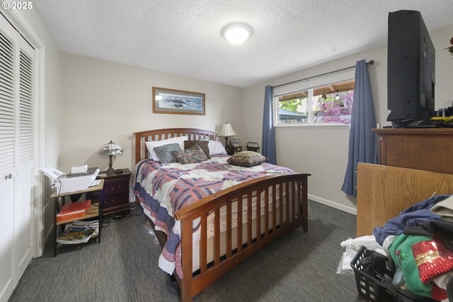 625 Crestview Dr, Reedsport, OR 97467 - bedroom with carpet floors, a textured ceiling, a closet, and baseboards