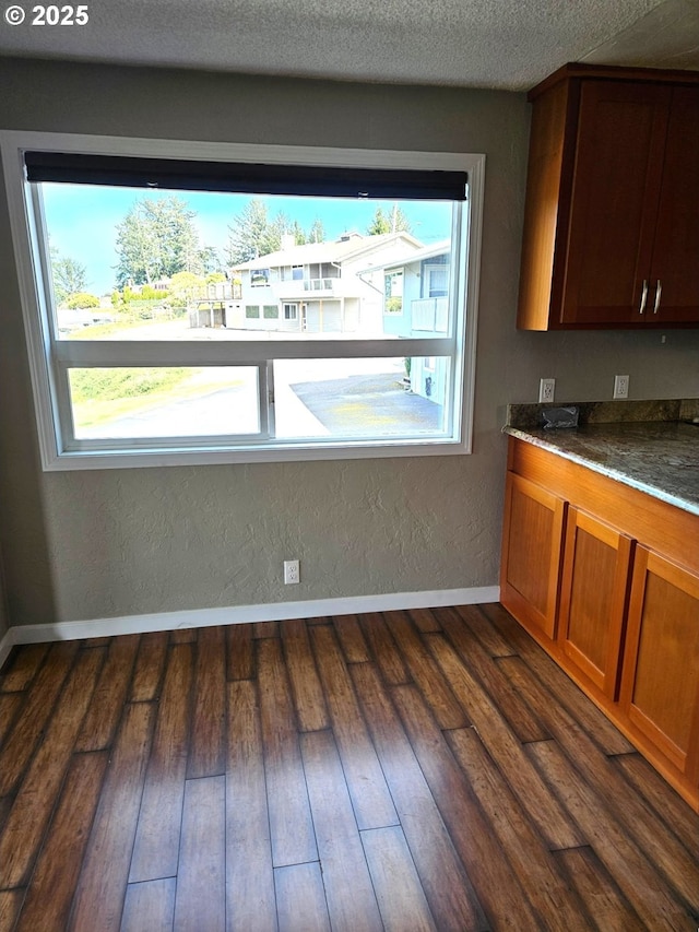 625 Crestview Dr, Reedsport, OR 97467 - kitchen featuring healthy amount of natural light, dark wood-style flooring, baseboards, and brown cabinetry