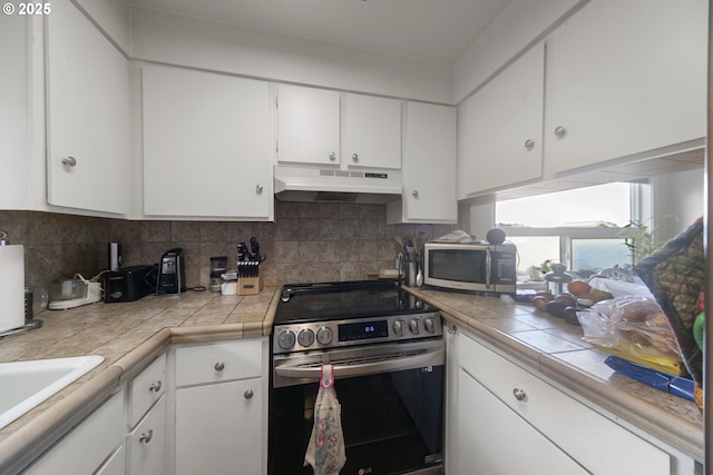 625 Crestview Dr, Reedsport, OR 97467 - kitchen with stainless steel appliances, exhaust hood, tasteful backsplash, and white cabinetry