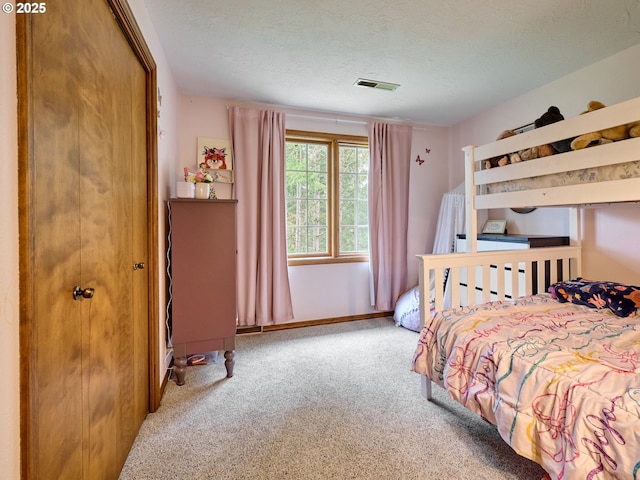 carpeted bedroom featuring visible vents, a textured ceiling, and baseboards