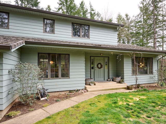 view of front of property featuring covered porch and a front yard