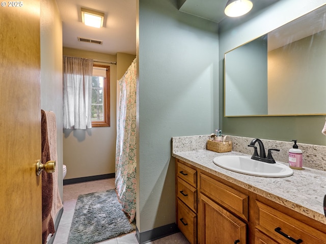 full bath with visible vents, toilet, vanity, tile patterned flooring, and baseboards