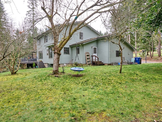 rear view of property with a yard and a wooden deck