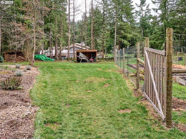 view of yard featuring fence and an outbuilding