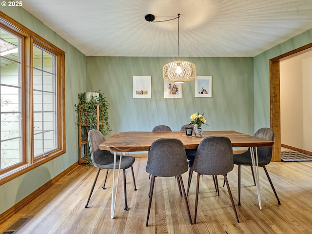 dining room with light wood-style floors, baseboards, and visible vents