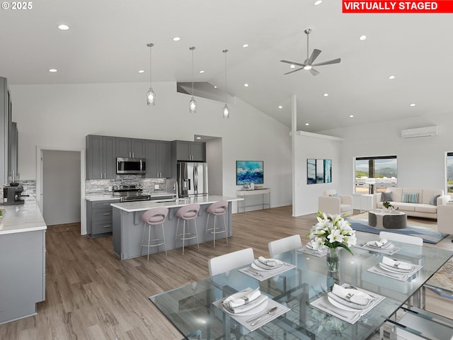 1091 N Echo Mountain Rd, Otis, OR 97368 - dining area featuring high vaulted ceiling, an AC wall unit, a ceiling fan, light wood finished floors, and recessed lighting