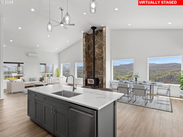 1091 N Echo Mountain Rd, Otis, OR 97368 - kitchen with dishwasher, a wall unit AC, high vaulted ceiling, open floor plan, and light wood finished floors