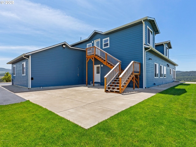 1091 N Echo Mountain Rd, Otis, OR 97368 - rear view of house with stairs, a yard, and a patio