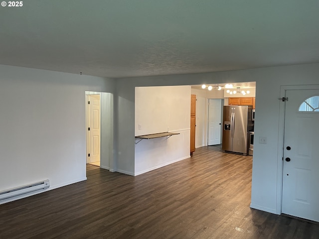 empty room with a baseboard heating unit and dark wood-type flooring