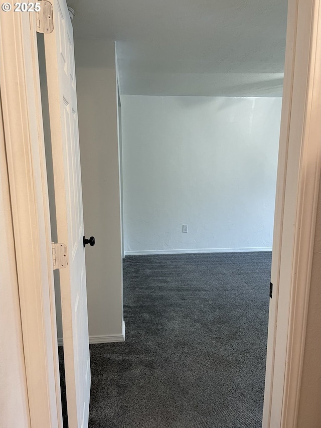 spare room featuring dark carpet