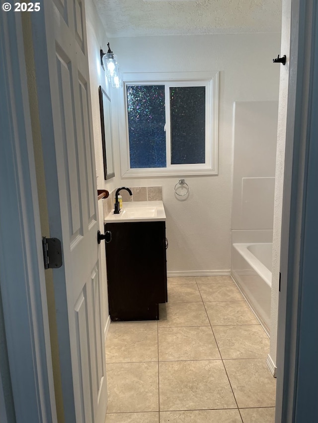 bathroom featuring vanity, tile patterned flooring, and a textured ceiling