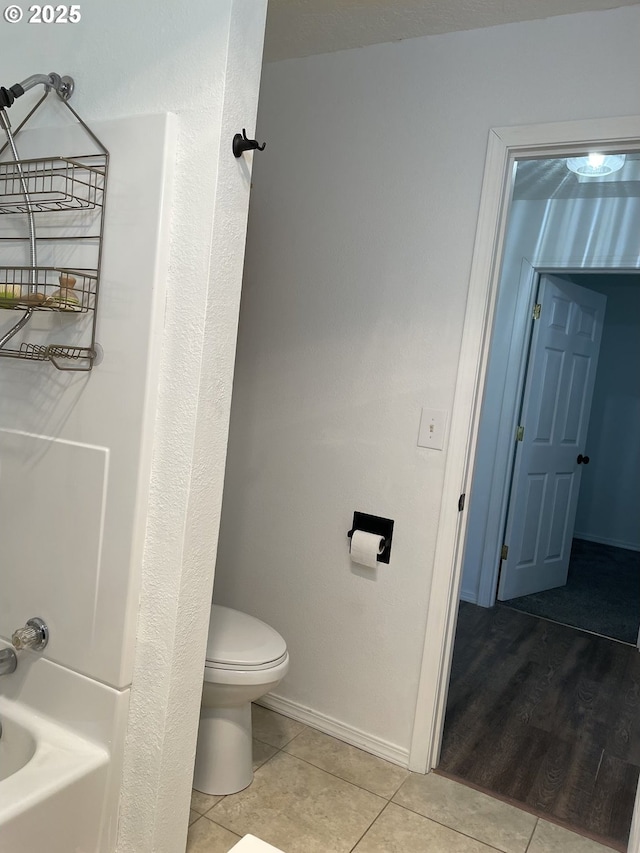 bathroom with  shower combination, toilet, and tile patterned flooring