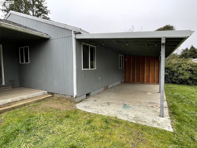 view of side of property with a carport and a yard