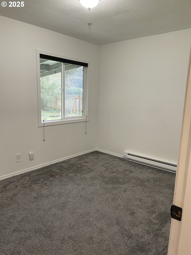 carpeted empty room featuring a baseboard radiator and a textured ceiling