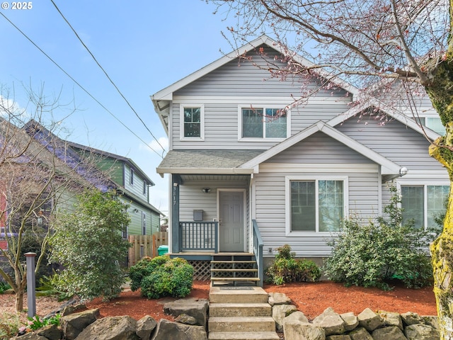 view of front of house featuring fence, a porch, and roof with shingles