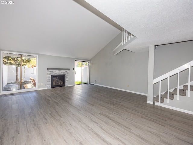unfurnished living room with baseboards, wood finished floors, and a fireplace