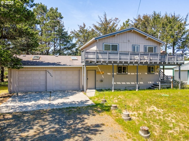 26750 David Ave, Rockaway Beach, OR 97136 - view of front of home featuring a wooden deck, concrete driveway, stairs, a front yard, and an attached garage