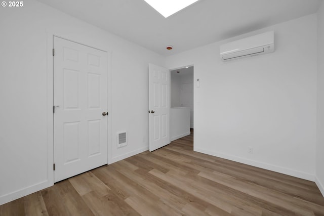 4070 Barger Dr, Eugene, OR 97402 - unfurnished bedroom featuring an AC wall unit and light wood-type flooring