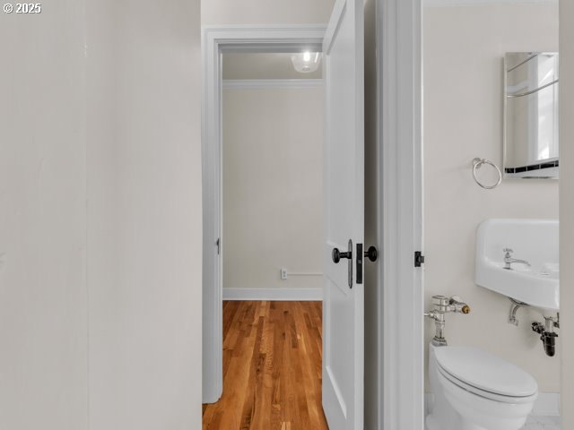 20 NW 16th Ave Unit 8, Portland, OR 97209 - half bath with a sink, baseboards, toilet, and wood finished floors