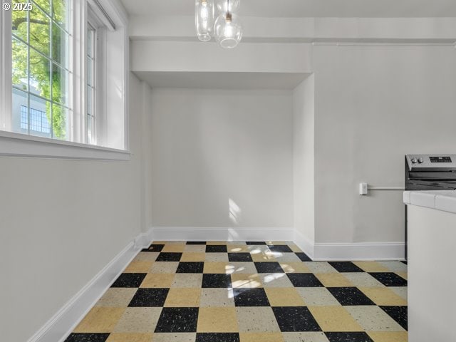 20 NW 16th Ave Unit 8, Portland, OR 97209 - unfurnished dining area featuring tile patterned floors, an inviting chandelier, and baseboards