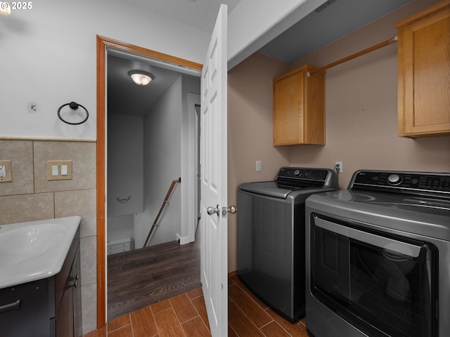 10727 NE Beech St, Portland, OR 97220 - laundry area with tile walls, washer and dryer, cabinet space, wood tiled floors, and wainscoting