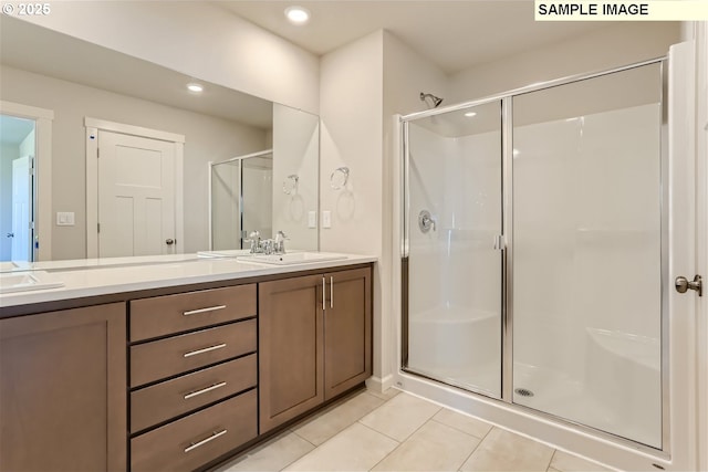bathroom featuring a shower stall, tile patterned floors, double vanity, and recessed lighting