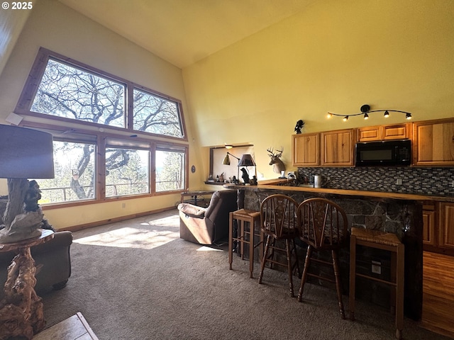87 Adams Loop Rd, Goldendale, WA 98620 - interior space featuring a wealth of natural light, carpet flooring, black microwave, and high vaulted ceiling