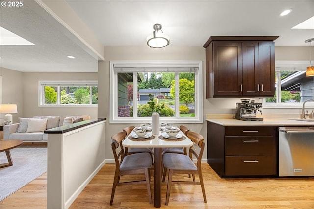 dining space with light wood-type flooring, baseboards, and a healthy amount of sunlight