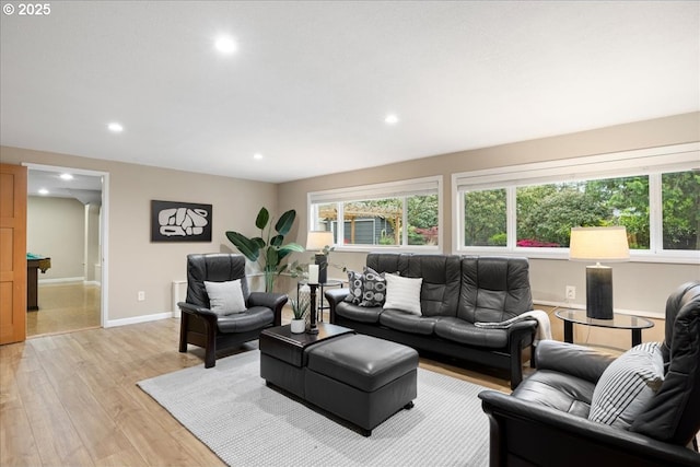 living area featuring recessed lighting, baseboards, and light wood-style flooring