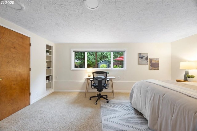 bedroom with carpet floors, baseboards, and a textured ceiling
