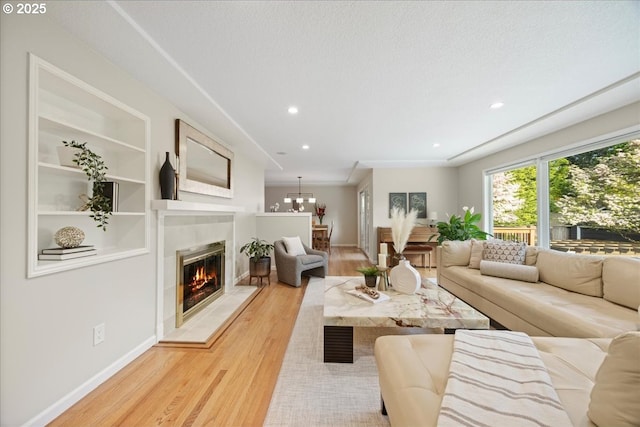 living area with visible vents, a tiled fireplace, baseboards, light wood finished floors, and recessed lighting