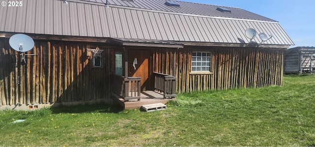 back of house featuring a lawn and metal roof