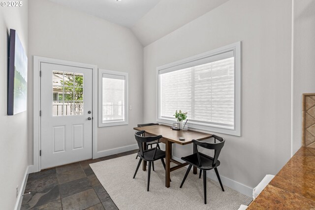 465 Covey Ln, Eugene, OR 97401 - dining room featuring baseboards, lofted ceiling, and dark stone finish flooring