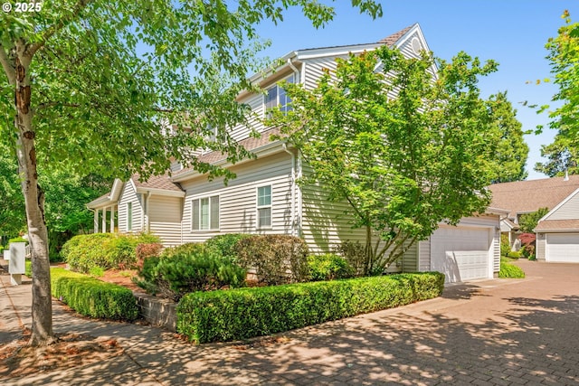 465 Covey Ln, Eugene, OR 97401 - obstructed view of property featuring a garage and decorative driveway
