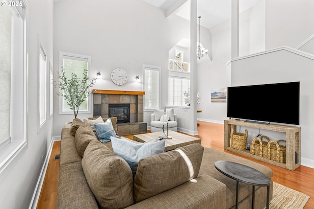 465 Covey Ln, Eugene, OR 97401 - living area featuring a high ceiling, a fireplace, wood finished floors, baseboards, and a chandelier