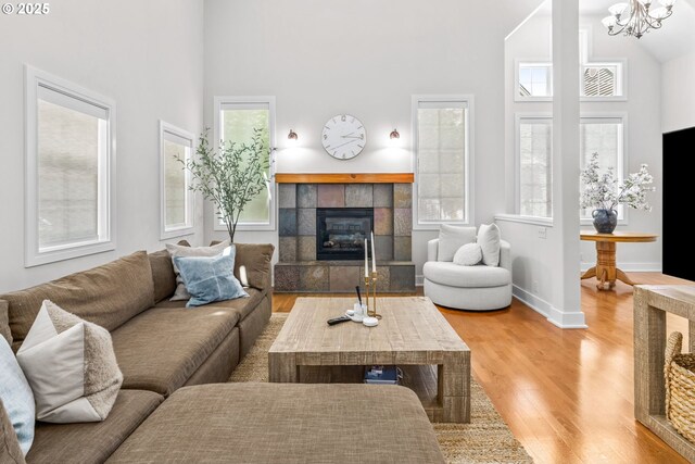 465 Covey Ln, Eugene, OR 97401 - living area with high vaulted ceiling, a tile fireplace, wood finished floors, baseboards, and a chandelier