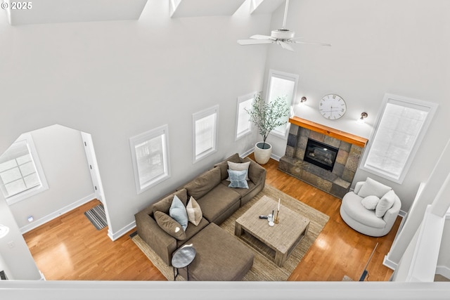 465 Covey Ln, Eugene, OR 97401 - living room featuring a high ceiling, a tiled fireplace, wood finished floors, a ceiling fan, and baseboards