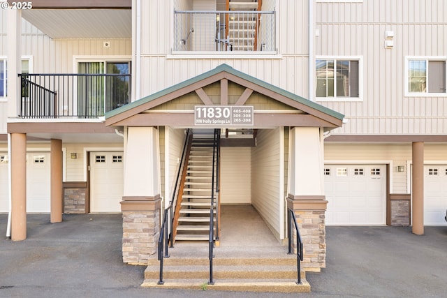 11830 NW Holly Springs Ln Unit 406, Portland, OR 97229 - view of exterior entry featuring a garage, stone siding, and driveway