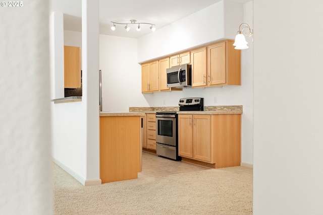 11830 NW Holly Springs Ln Unit 406, Portland, OR 97229 - kitchen featuring stainless steel appliances, light brown cabinetry, and light colored carpet