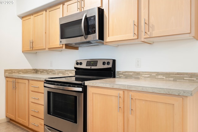 11830 NW Holly Springs Ln Unit 406, Portland, OR 97229 - kitchen featuring stainless steel appliances, light brown cabinetry, and tile counters