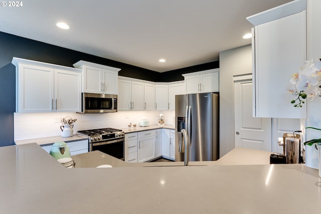 kitchen with appliances with stainless steel finishes, white cabinets, tasteful backsplash, and recessed lighting