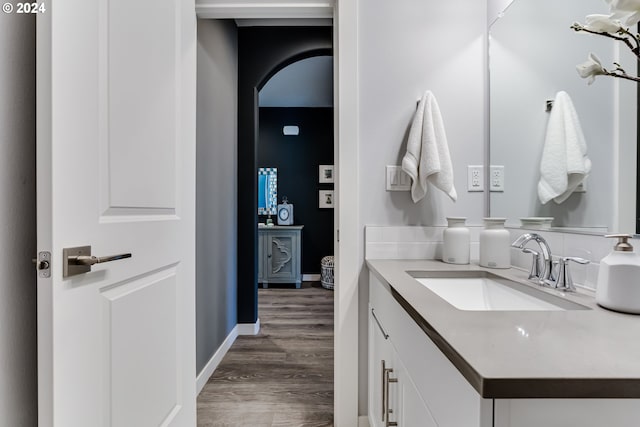 bathroom with wood finished floors, vanity, and baseboards