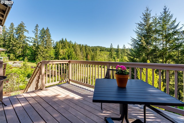 wooden terrace with a wooded view