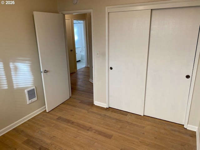 unfurnished bedroom with a closet and wood-type flooring